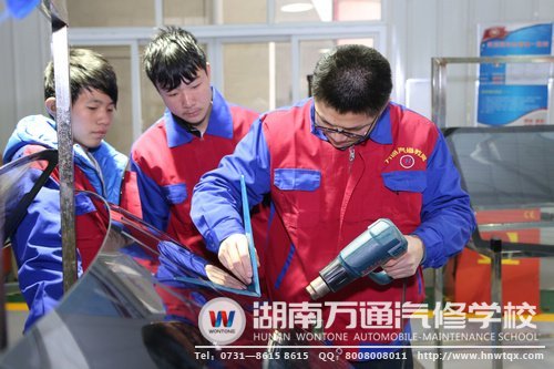 汽車美容裝潢專業(yè)新生正在學(xué)習(xí)汽車貼膜